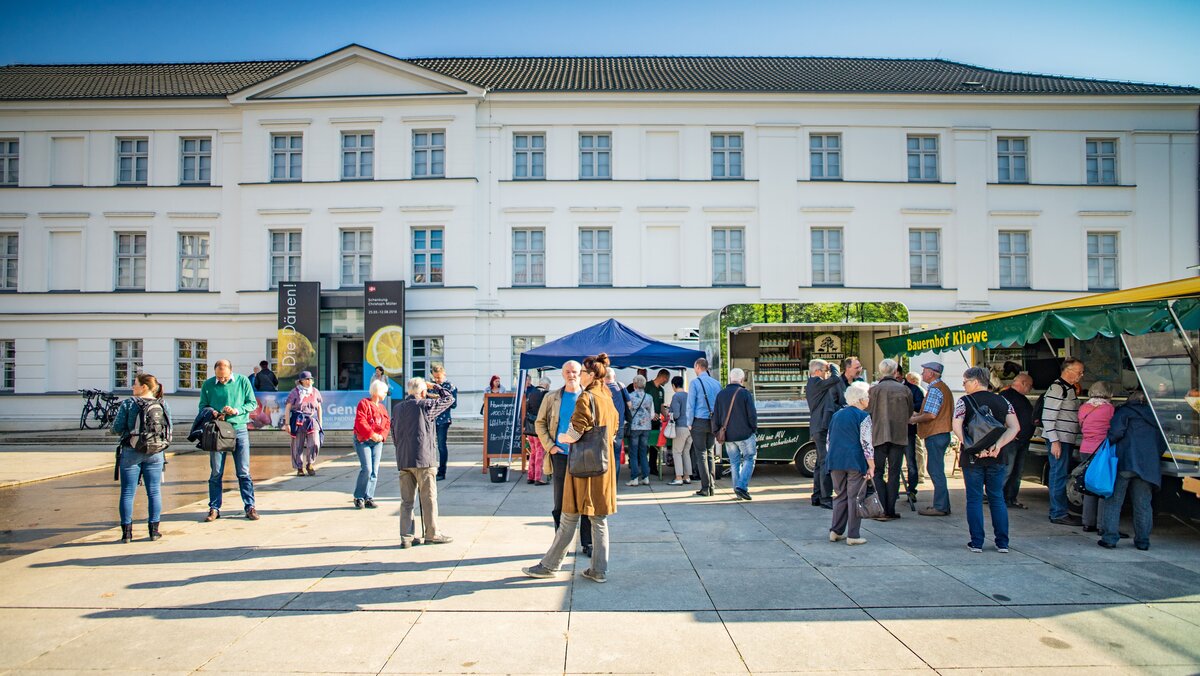 Besucher auf der Regionalproduktemesse an den Außenständen vor dem Pommerschen Landesmuseum.