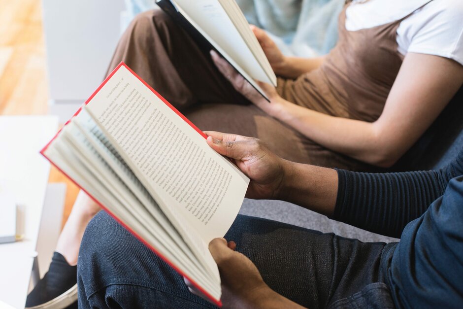 [Translate to English:] Nahaufnahme von einem aufgeschlagenem Buch, dass von einer Person gehalten wird.