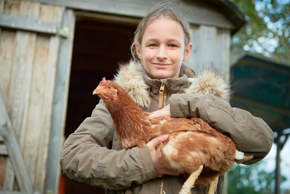 Kind mit Huhn auf dem Arm